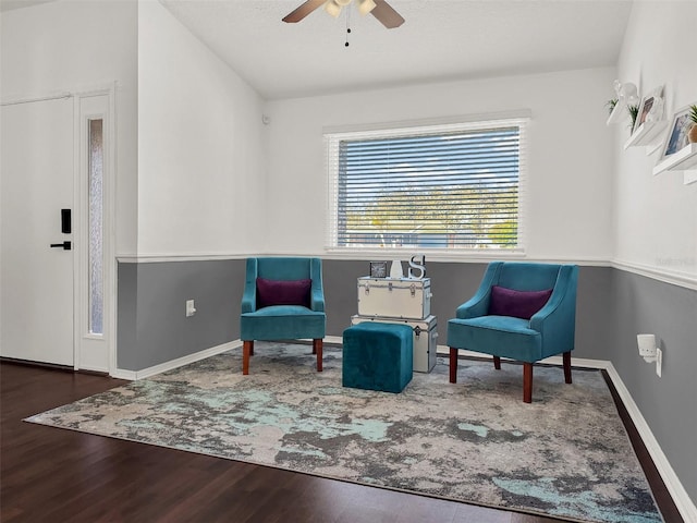 living area featuring baseboards, a ceiling fan, and wood finished floors