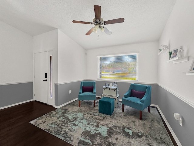 living area with baseboards, ceiling fan, a textured ceiling, and wood finished floors