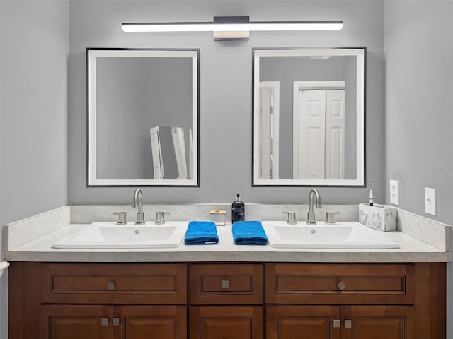 full bathroom with double vanity and a sink