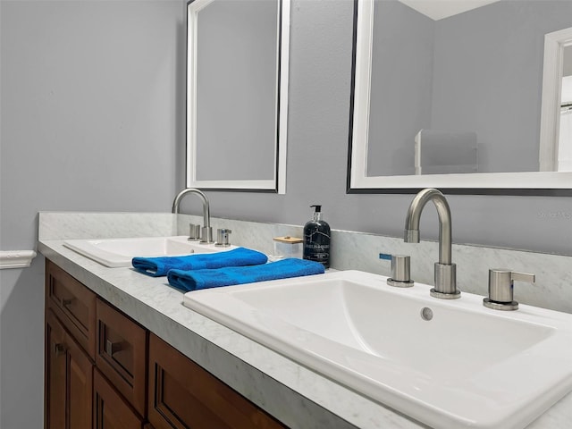 bathroom featuring a sink and double vanity