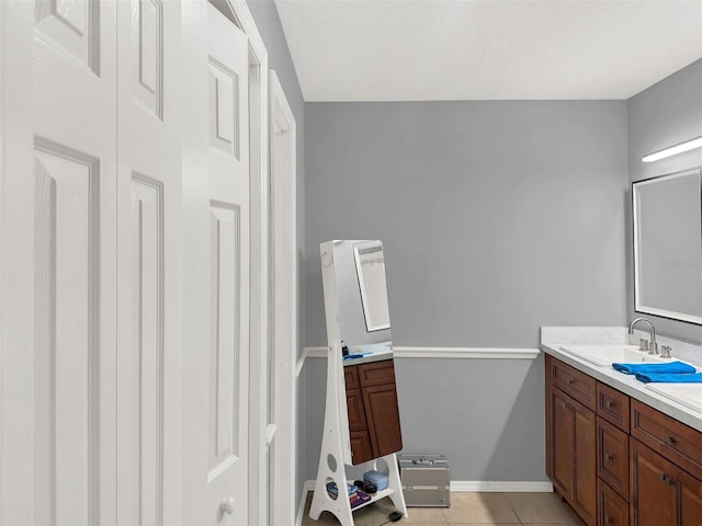 bathroom with vanity, baseboards, and tile patterned floors