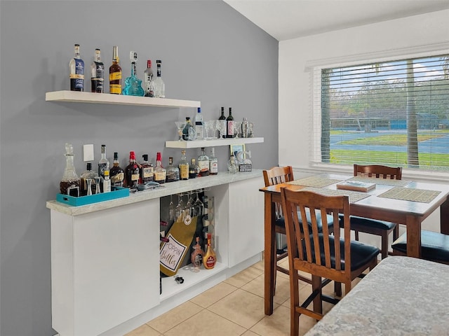 bar featuring a dry bar and light tile patterned flooring