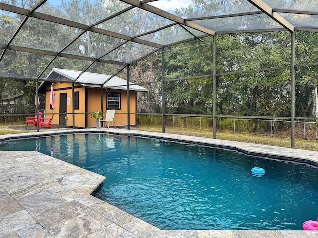 outdoor pool with a lanai, an outbuilding, and a patio