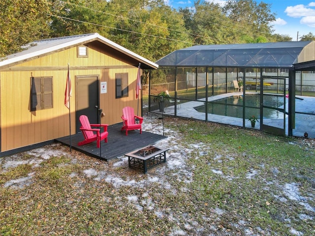exterior space featuring an outdoor pool and an outdoor fire pit