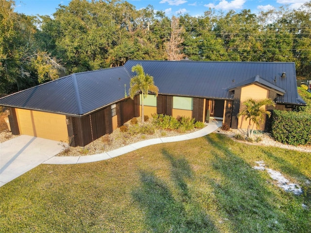 single story home with driveway, metal roof, and a front yard