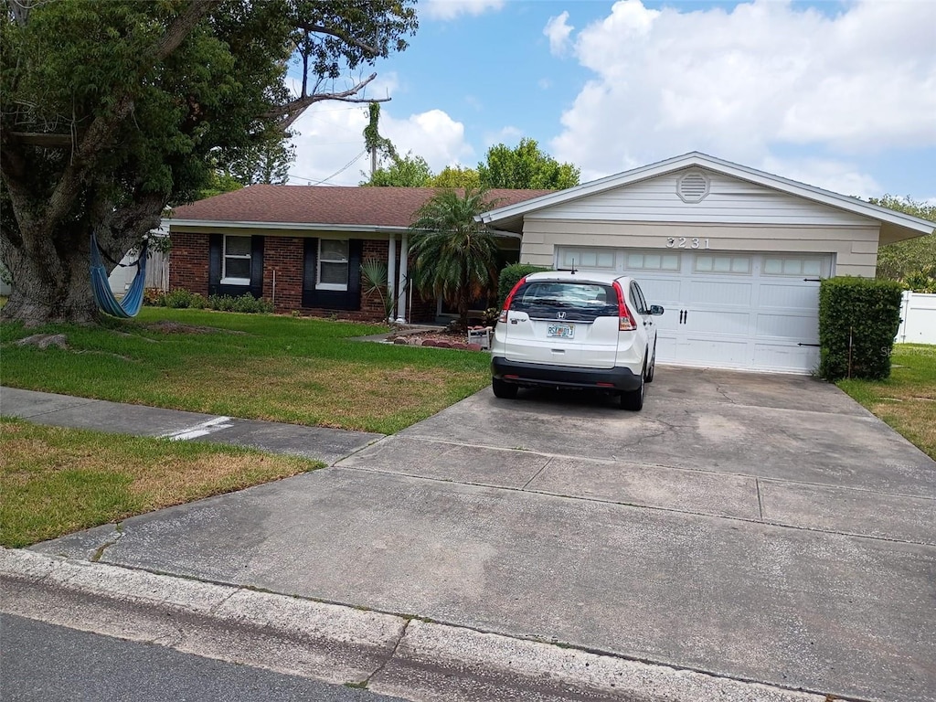 3231 Lowndes Dr, Winter Park, FL 32792 - single story home featuring concrete driveway, a front yard, and an attached garage