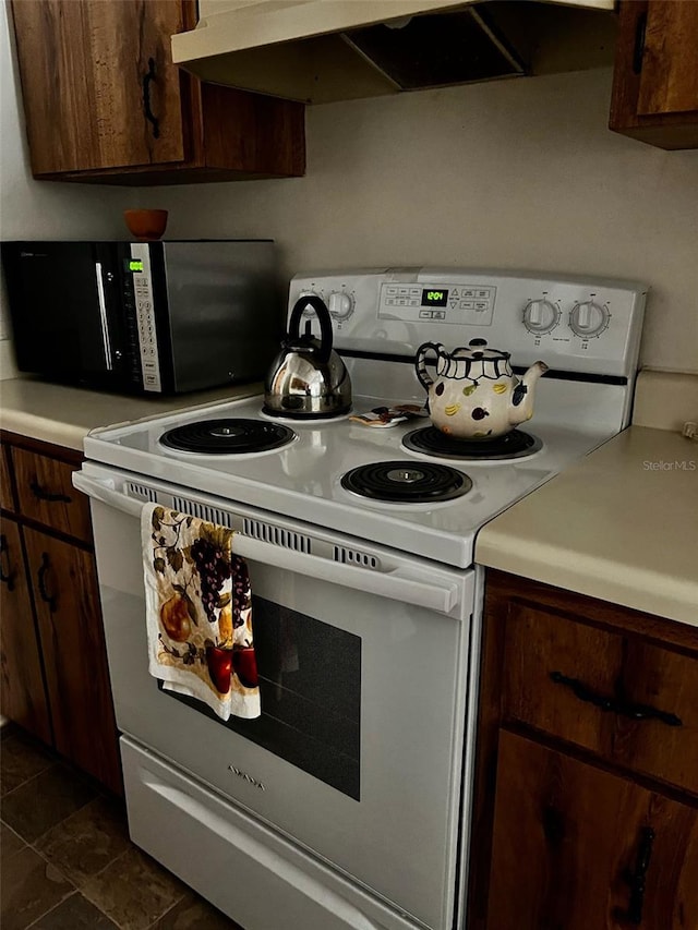 2659 Crown Ct Unit 11, Kissimmee, FL 34741 - kitchen featuring light countertops, dark brown cabinetry, electric range, and under cabinet range hood