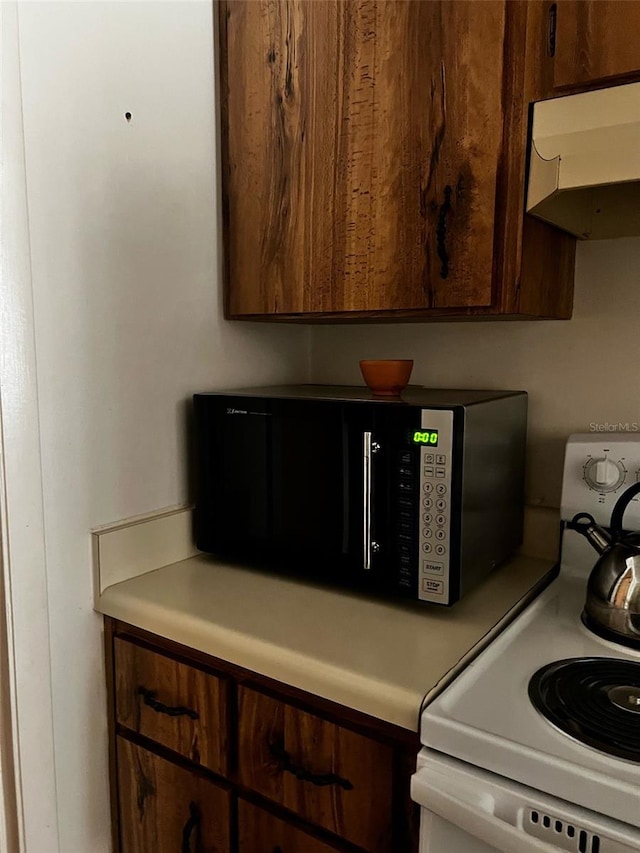 2659 Crown Ct Unit 11, Kissimmee, FL 34741 - room details with black microwave, light countertops, under cabinet range hood, and white electric range