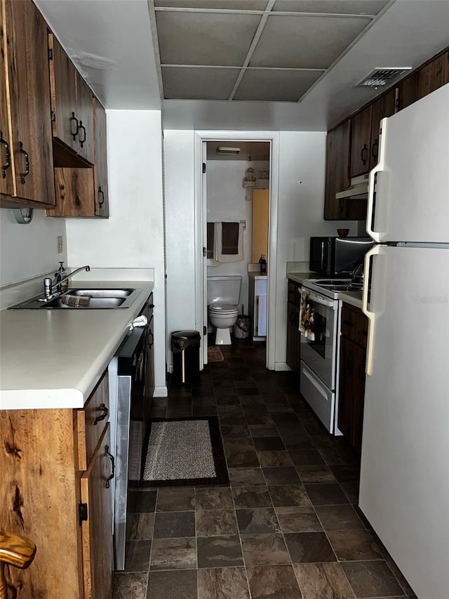 2659 Crown Ct Unit 11, Kissimmee, FL 34741 - kitchen with a sink, under cabinet range hood, range with electric cooktop, light countertops, and freestanding refrigerator