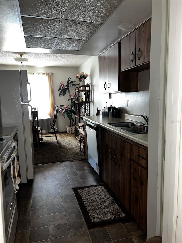 2659 Crown Ct Unit 11, Kissimmee, FL 34741 - kitchen featuring a sink, dishwashing machine, dark brown cabinets, and stainless steel electric range