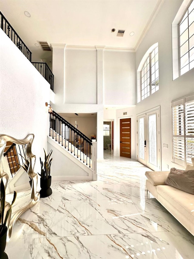 living area featuring stairs, a high ceiling, and marble finish floor