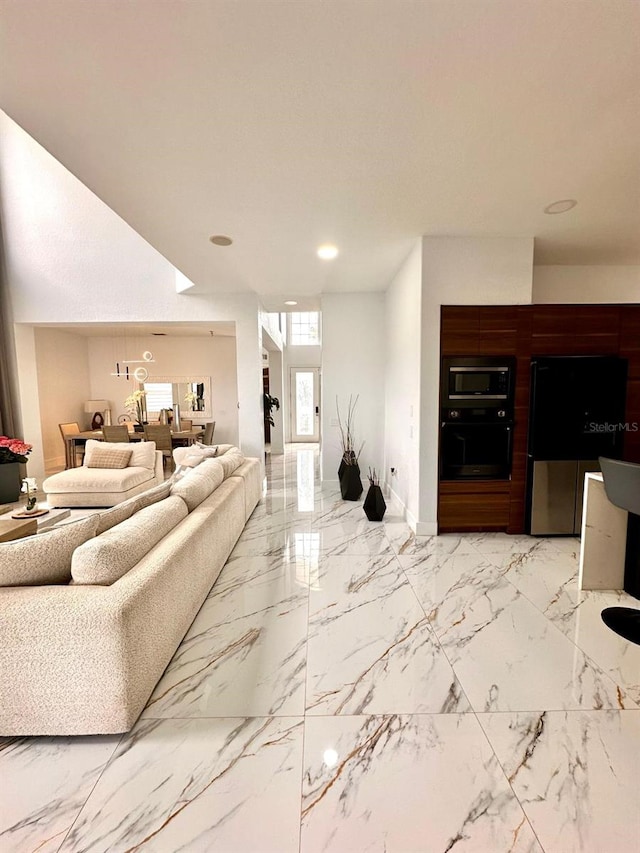 living area with baseboards, recessed lighting, and marble finish floor