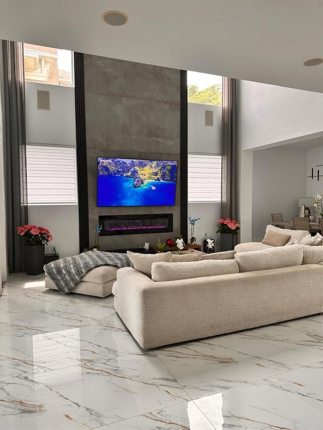 living area featuring marble finish floor and a healthy amount of sunlight