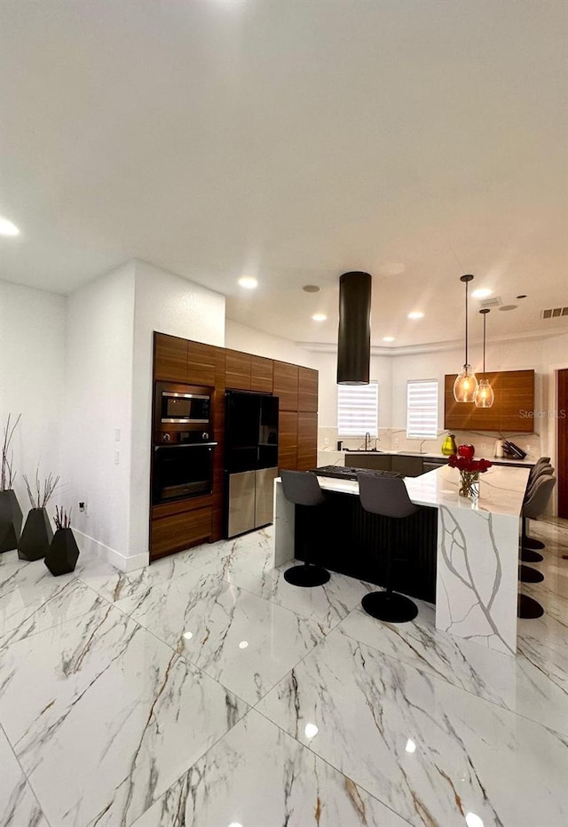 kitchen featuring a spacious island, appliances with stainless steel finishes, brown cabinets, visible vents, and modern cabinets
