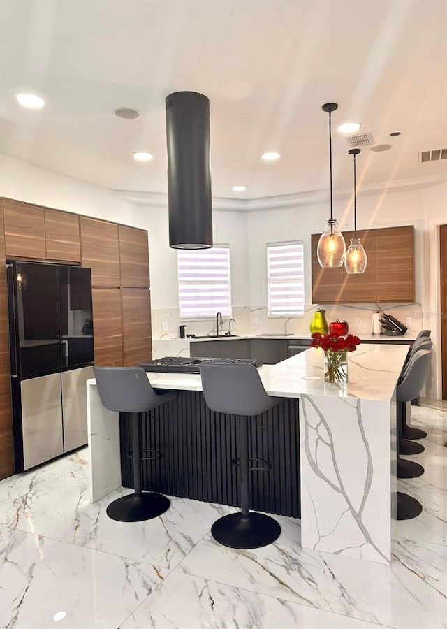 kitchen with brown cabinets, smart refrigerator, a large island, and visible vents