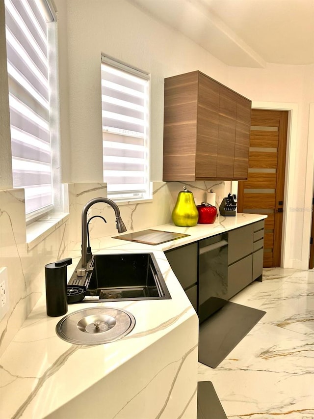 kitchen featuring a sink, modern cabinets, brown cabinets, decorative backsplash, and light countertops