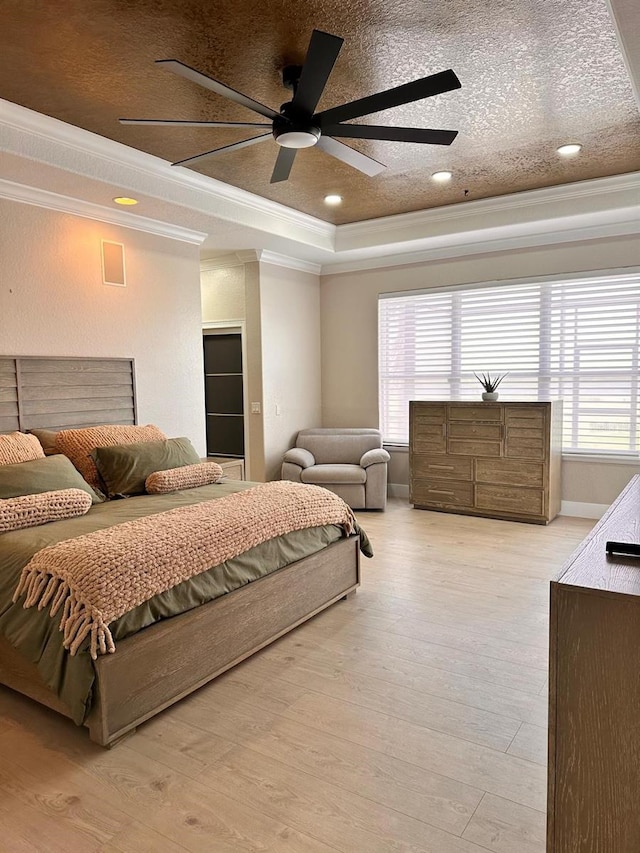 bedroom with crown molding, a tray ceiling, and multiple windows