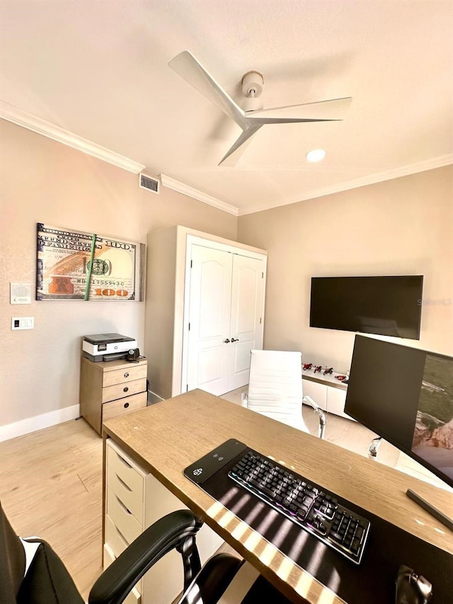 office featuring light wood finished floors, ceiling fan, visible vents, baseboards, and ornamental molding