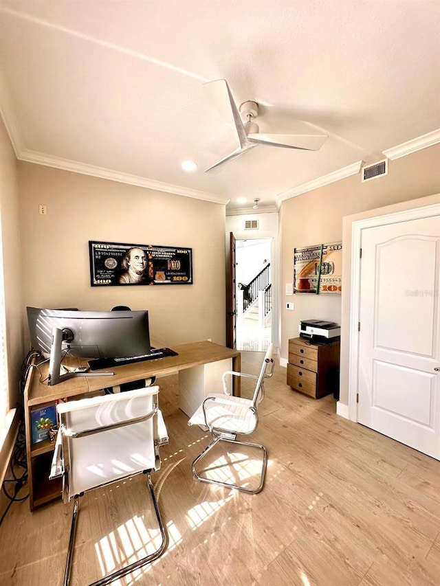 office space with visible vents, light wood finished floors, ceiling fan, and ornamental molding
