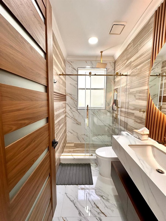 bathroom featuring marble finish floor, tile walls, ornamental molding, toilet, and a marble finish shower