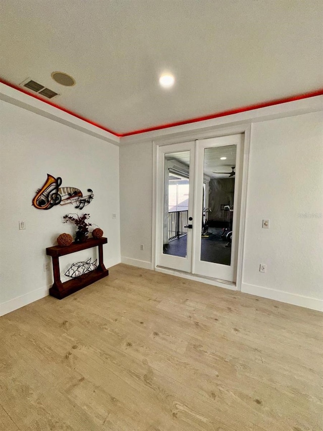 empty room featuring visible vents, baseboards, and light wood-style floors