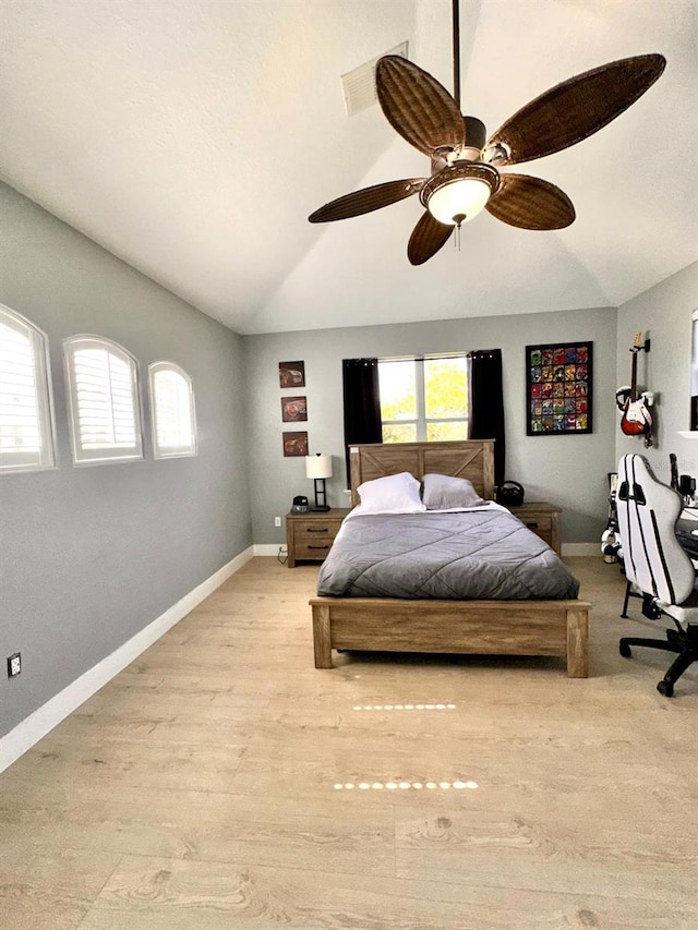 bedroom with visible vents, light wood-style floors, multiple windows, and vaulted ceiling
