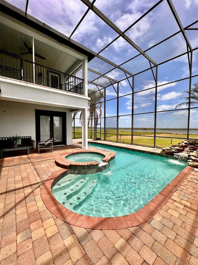 view of swimming pool with a lanai, a pool with connected hot tub, and a patio area