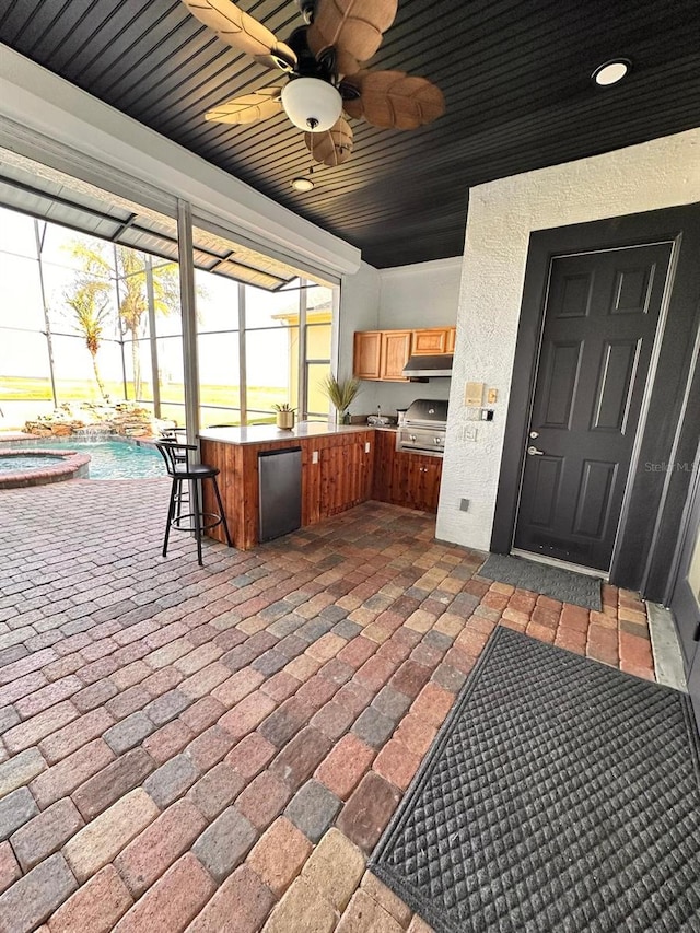 view of patio with outdoor wet bar, a lanai, exterior kitchen, a ceiling fan, and an outdoor pool