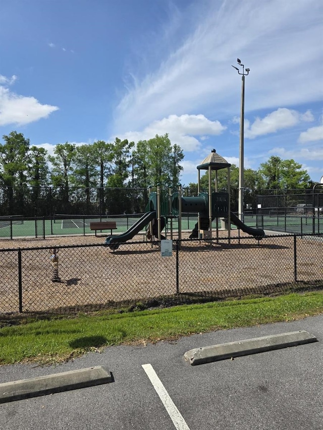 community playground featuring a tennis court and fence