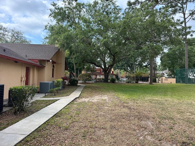 view of yard featuring central air condition unit and fence