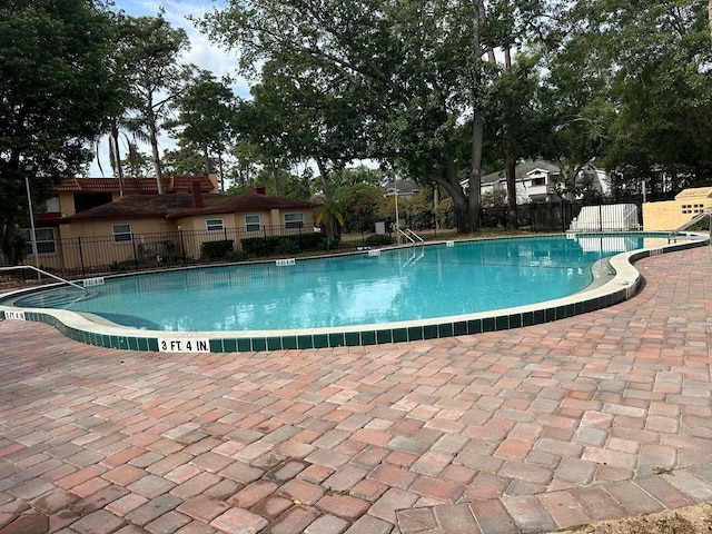 pool with fence and a patio area