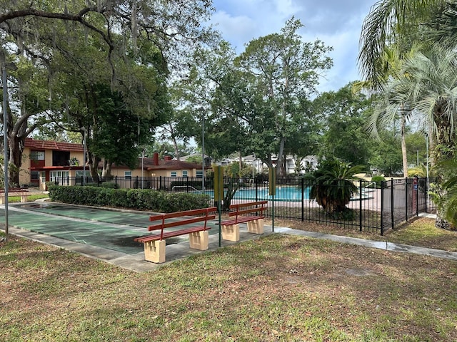 surrounding community featuring fence, a pool, and shuffleboard