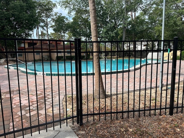 community pool featuring fence and a patio area
