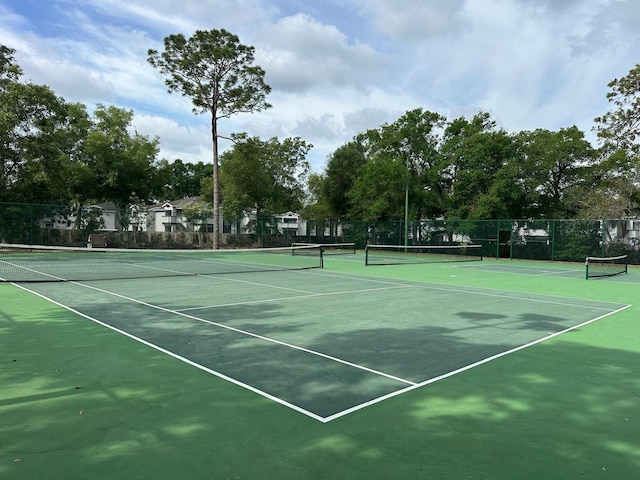 view of tennis court featuring fence and community basketball court