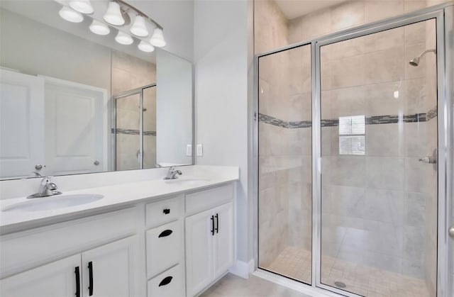 bathroom featuring double vanity, a sink, and a stall shower