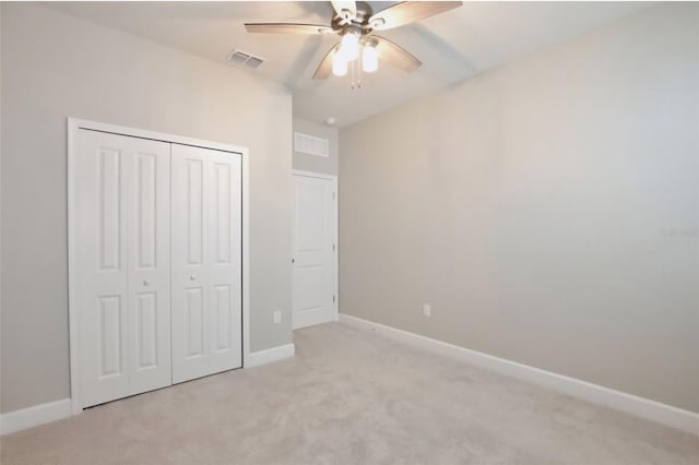 unfurnished bedroom with light colored carpet, a ceiling fan, baseboards, visible vents, and a closet