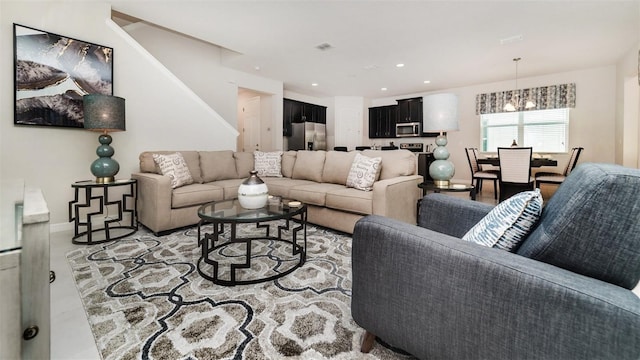 living area with stairway, visible vents, recessed lighting, and a notable chandelier
