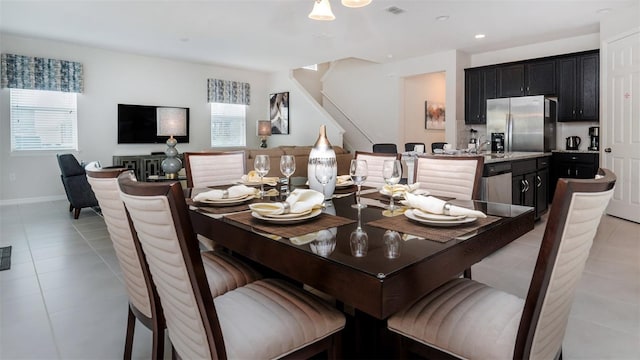 dining space featuring light tile patterned floors, visible vents, baseboards, recessed lighting, and stairs