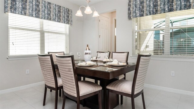 dining room with baseboards, light tile patterned floors, and a notable chandelier