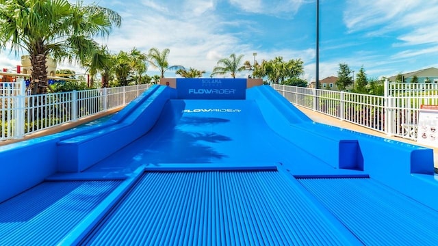 view of swimming pool featuring fence
