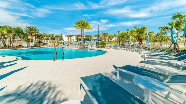 community pool with fence and a patio