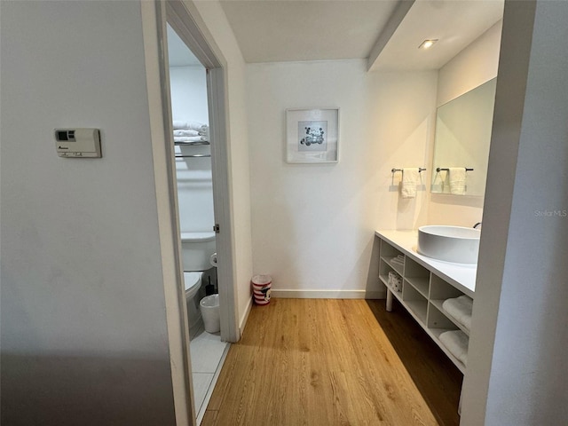 5245 W Irlo Bronson Memorial Hwy Unit 210, Kissimmee, FL 34746 - bathroom with toilet, wood finished floors, vanity, and baseboards