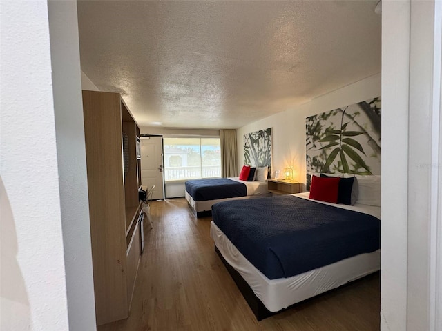 5245 W Irlo Bronson Memorial Hwy Unit 210, Kissimmee, FL 34746 - bedroom with a textured ceiling and wood finished floors