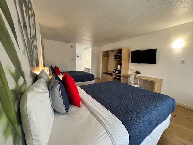 5245 W Irlo Bronson Memorial Hwy Unit 210, Kissimmee, FL 34746 - bedroom featuring baseboards, wood finished floors, and a textured ceiling