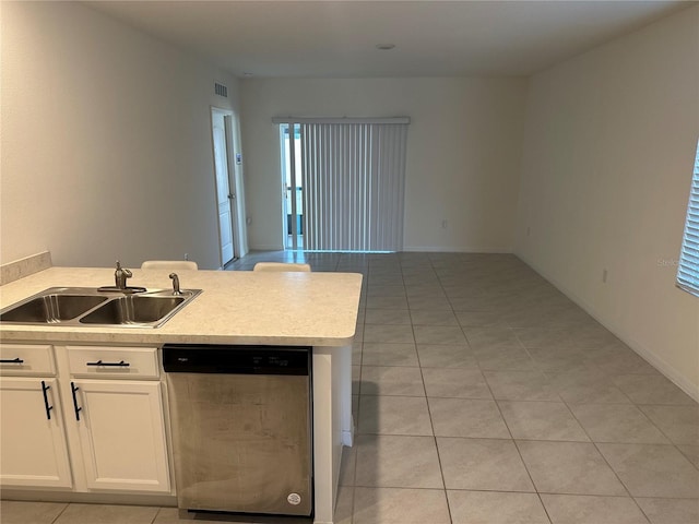kitchen featuring light tile patterned floors, stainless steel dishwasher, white cabinets, a sink, and light countertops