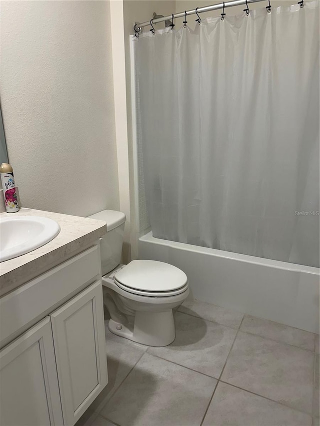 full bath featuring tile patterned floors, toilet, vanity, and shower / tub combo with curtain