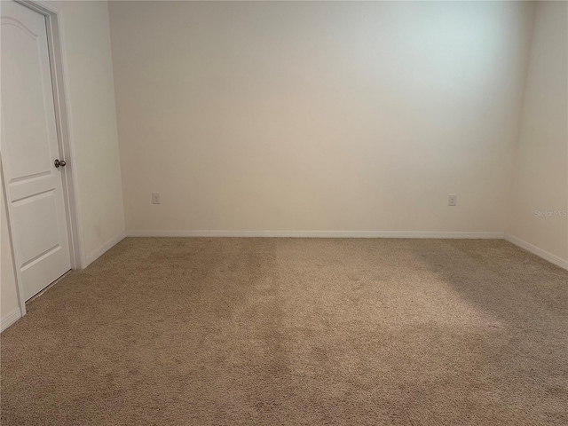 unfurnished room featuring baseboards and light colored carpet