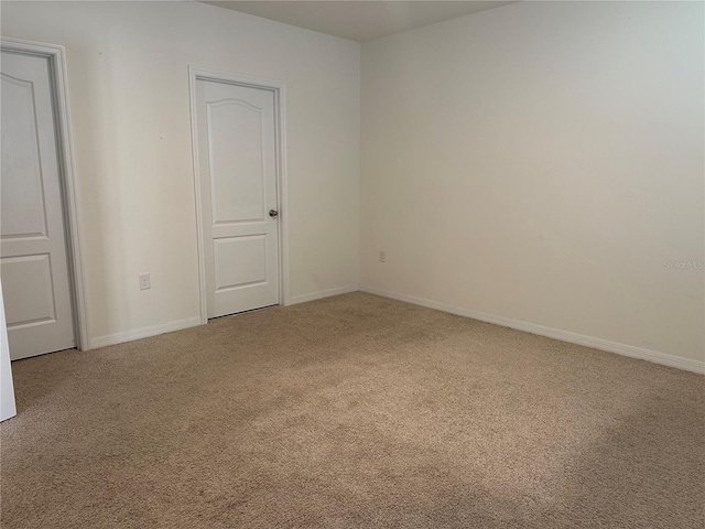 unfurnished room featuring carpet flooring and baseboards