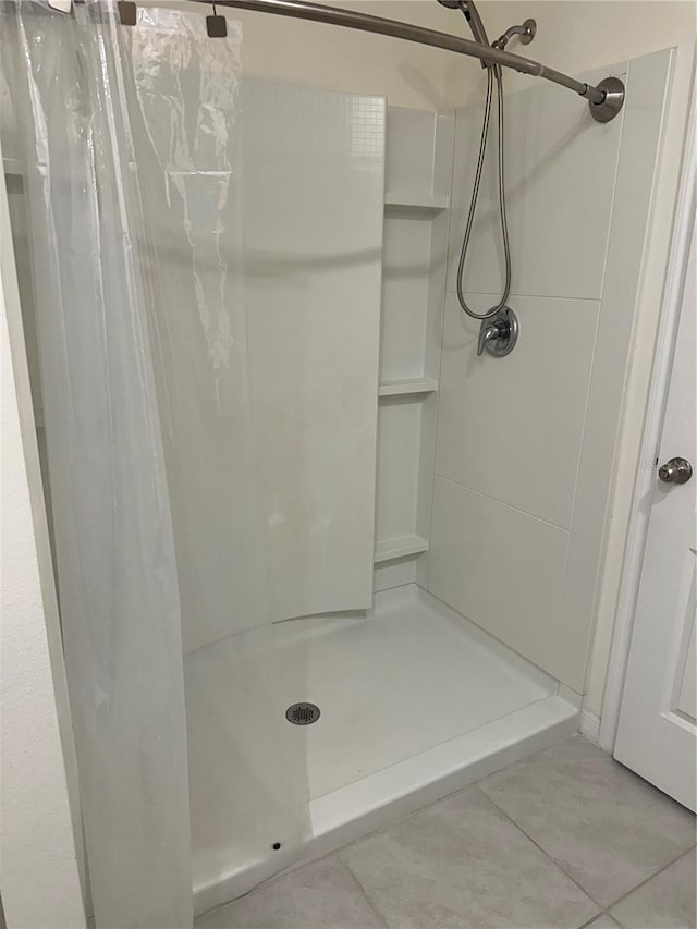 bathroom featuring tile patterned floors and a stall shower