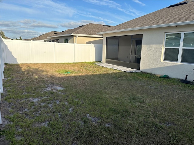 view of yard with fence and a sunroom